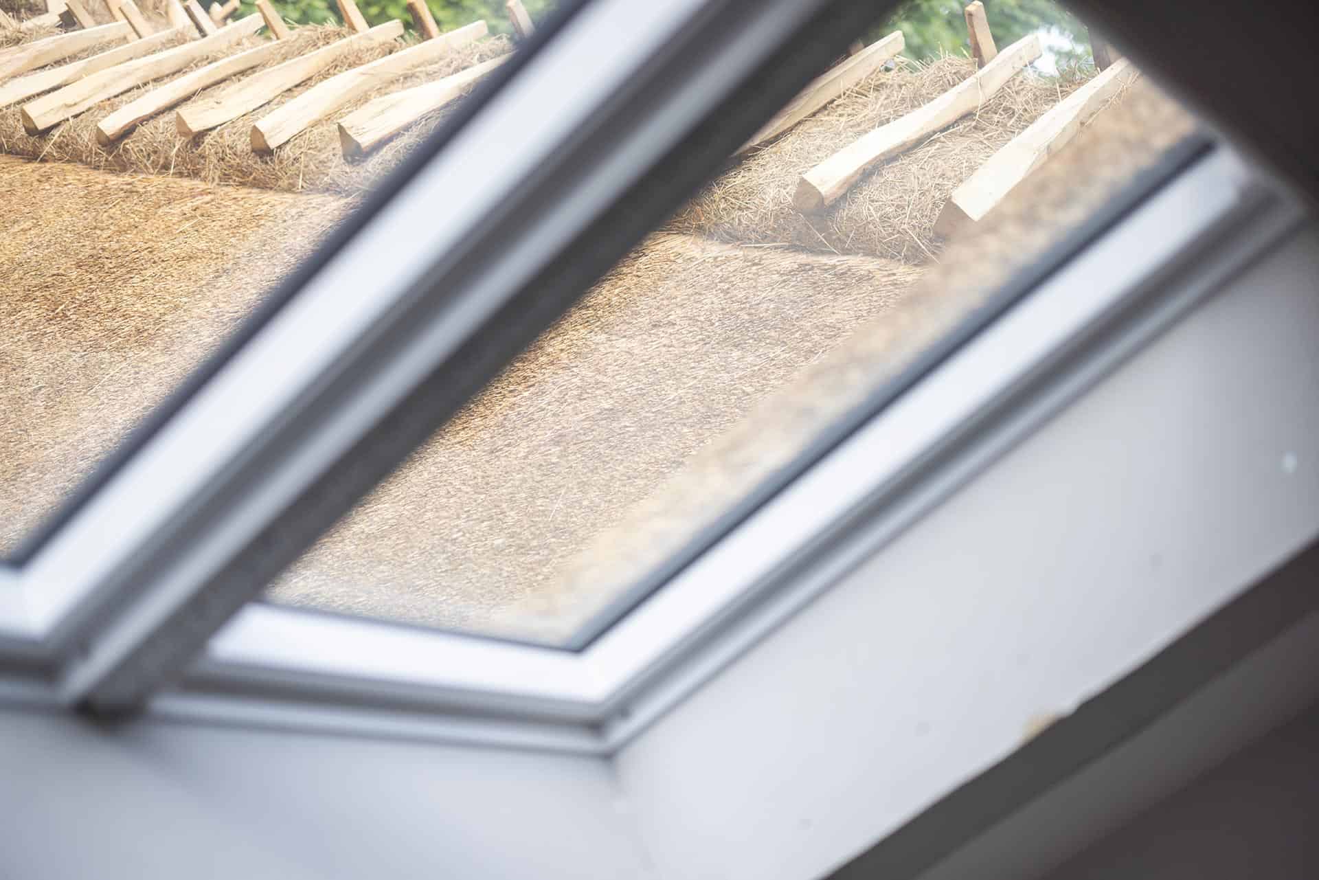 Billede ud af vindue med stråtag i baggrund